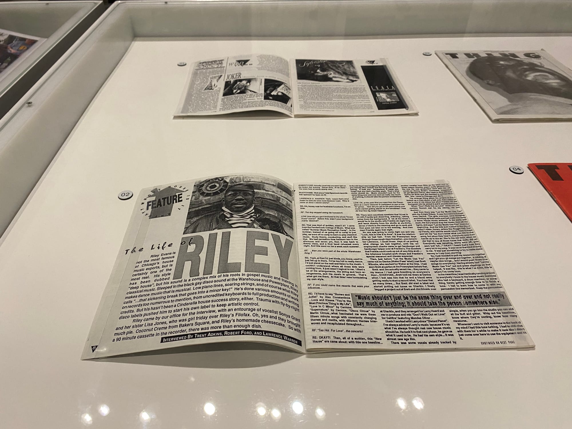 Two open magazines in a glass case, with closed magazines to the right of these open magazines.