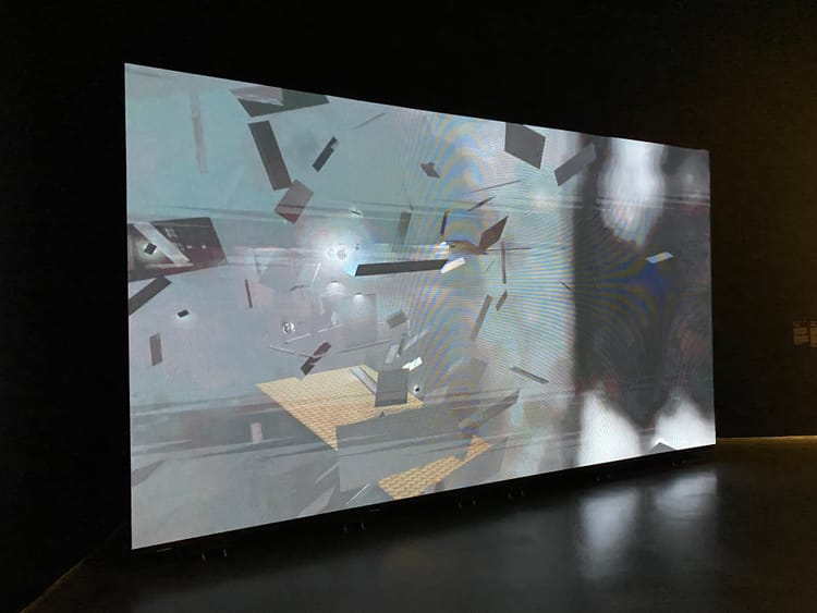 Projection of video by Amina Ross; space displayed is open game space with grey fragments moving, meant to visualize a bathhouse.
