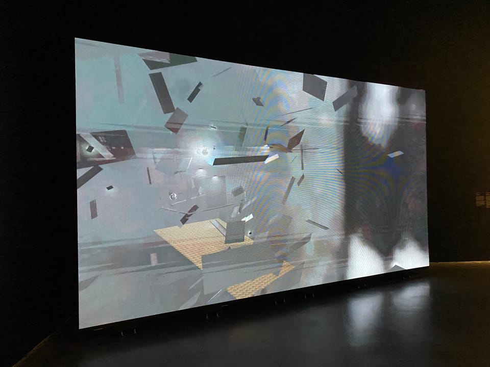 Projection of video by Amina Ross; space displayed is open game space with grey fragments moving, meant to visualize a bathhouse.